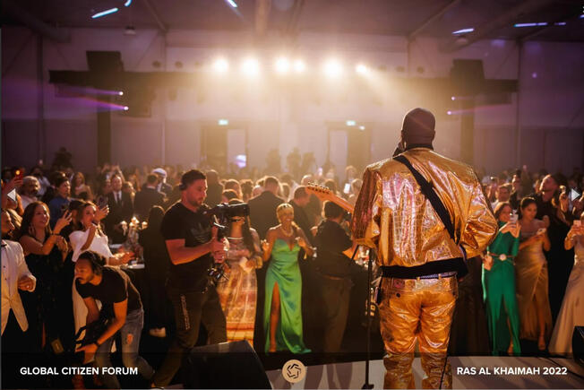 Adora Aiza spotted at Global Citizen Forum with Wyclef center stage in Las Al Khaimah , UAE with a star studded guest list and performance line up. Photo Credit: Getty Celebrity charity event to help families in need with singer Adora Aiza in attendance with long emerald green dress and gold head piece.